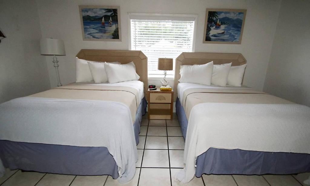 Double Queen room with two queen beds, white linens, and blue accents
